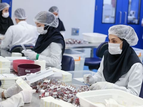 Pharmaceutical factory workers package vitamin and mineral supplement ampoules at the Actoverco plant in Karaj, about 40 kilometres (nearly 25 miles) west of Iran's capital Tehran, on February 18, 2020. 