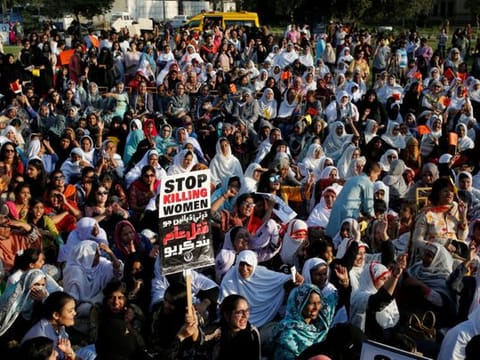 People hold signs and chant slogans as they take part in an Aurat March, or Women’s March in Karachi, Pakistan March 8, 2018. 