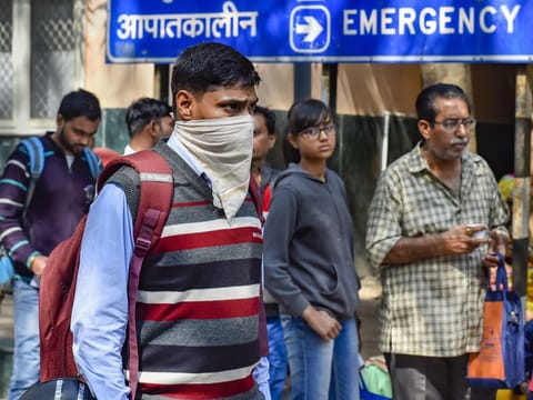 A man uses a handkerchief to cover his face in the wake of the coronavirus outbreak at RML Hospital in New Delhi on Tuesday. India on Monday reported two new cases of the virus, including one from the national capital.
