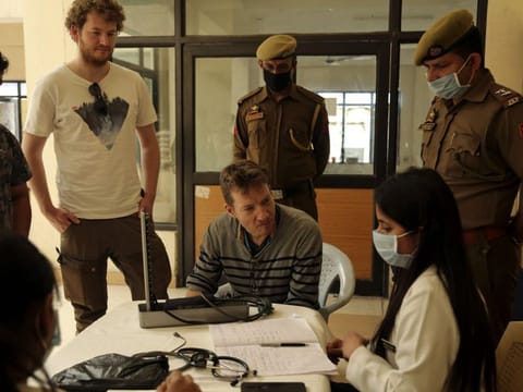 An Indian doctor checks the foreign (German) tourists at  coronavirus screening camp in Lakhanpur 92km from Jammu on Wednesday.