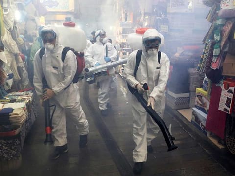 Firefighters disinfect a traditional shopping center to help prevent the spread of the new coronavirus in northern Tehran, Iran