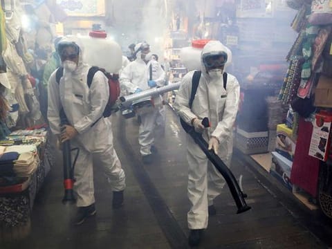 Firefighters disinfect a traditional shopping center to help prevent the spread of the new coronavirus in northern Tehran, Iran