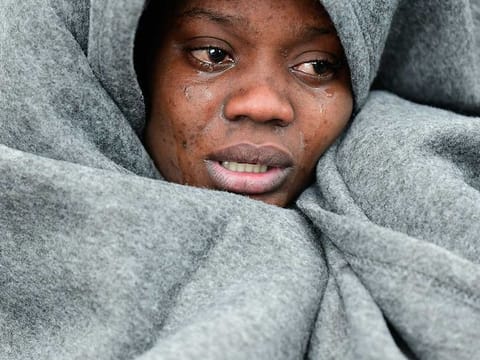 A migrant cries as she tries to warm herself as she and others arrive at the village of Skala Sikaminias, on the Greek island of Lesbos, after crossing the Aegean sea from Turkey