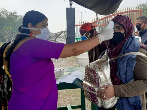 Government health officials use a thermal screening device on Bangladeshis entering into India to detect symptoms of Covid-19, at a temporary medical camp in Fulbari, Indo-Bangladesh Border on Monday.
