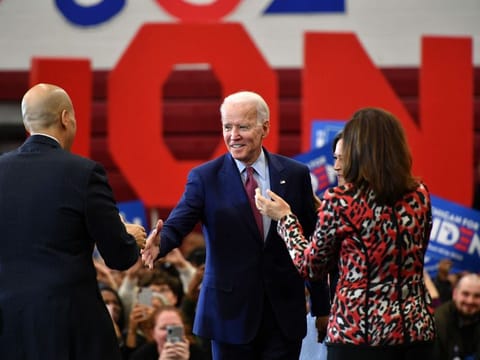 Democratic presidential candidate Joe Biden (C) greets New Jersey Senator Cory Booker (L) as California Senator Kamala Harris (L) and Michigan Governor Gretchen Whitmer (R) cheer during a campaign rally at Renaissance High School in Detroit, Michigan on March 9, 2020.