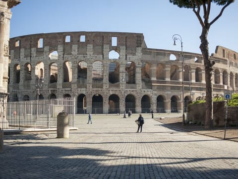A few pedestrians walk near the Colosseum in Rome, Italy, on Wednesday. Italian Prime Minister Giuseppe Conte’s government is ready to spend as much as 25 billion euros ($28.3 billion) on stimulus measures to shield the economy from Europe's worst outbreak of the coronavirus.