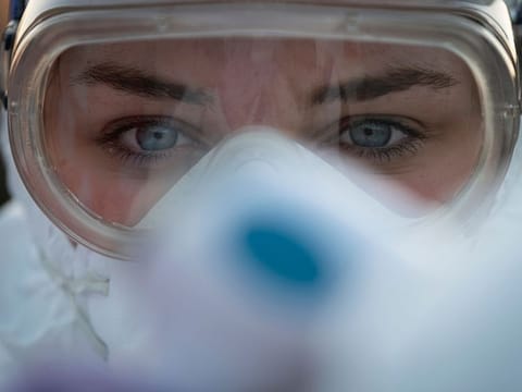 A medical worker wears protective goggles as she prepares to measure motorists' body temperatures  at the Slovenian-Italian border crossing near Nova Gorica, on March 11, 2020, after Slovenia's government announced it would close its border with Italy, hard hit by the outbreak of COVID-19, the new coronavirus. 