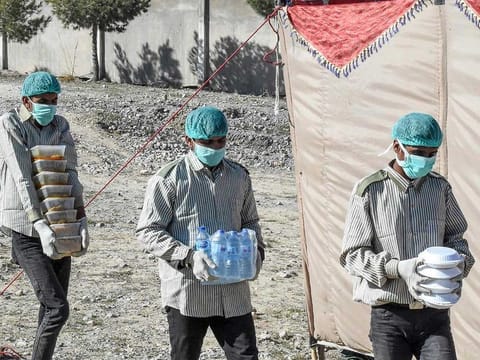 Workers of the Provincial Disaster Management Authority of Balochistan carry food for pilgrims at a quarantine camp prepared for people returning from Iran via the Pakistan-Iran border town of Taftan to prevent the spread of coronavirus, on the outskirts of Quetta. Pakistan has begun a probe after two journalists alleged that paramilitary forces tortured them for reporting on a coronavirus quarantine centre.
