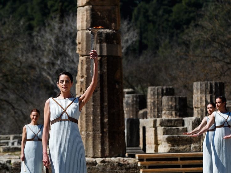 Greek actress Xanthi Georgiou, playing the role of the High Priestess, holds up the torch during the flame lighting ceremony at the closed Ancient Olympia site, birthplace of the ancient Olympics in southern Greece, Thursday, March 12, 2020. Greek Olympic officials are holding a pared-down flame-lighting ceremony for the Tokyo Games due to concerns over the spread of the coronavirus. Both Wednesday's dress rehearsal and Thursday's lighting ceremony are closed to the public, while organizers have slashed the number of officials from the International Olympic Committee and the Tokyo Organizing Committee, as well as journalists at the flame-lighting. (AP Photo/Thanassis Stavrakis)