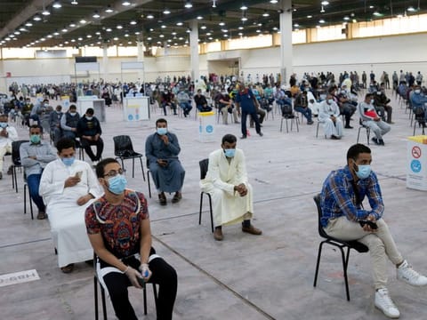 Expatriates wait for mandatory coronavirus testing in a makeshift testing centre in Mishref, Kuwait  on March 14.