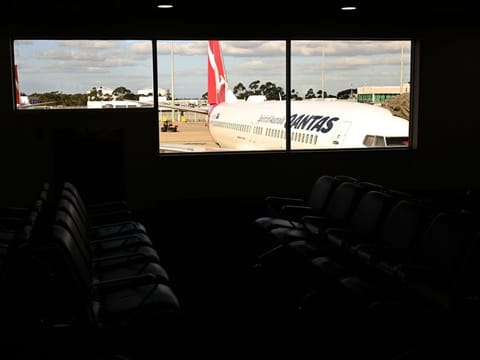 Photo taken on March 14 shows a plane sitting at a gate at Tullamarine Airport in Melbourne.  Australia announced on March 15 that anyone arriving into the country will face mandatory 14-day self-isolation, in a bid to slow the spread of the coronavirus. 