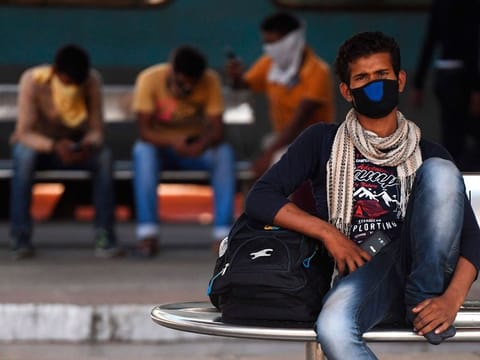 Passengers wearing facemasks amid concerns over the spread of the COVID-19 novel coronavirus, wait for their train at M.G.R.Central railway station in Chennai on March 16, 2020.