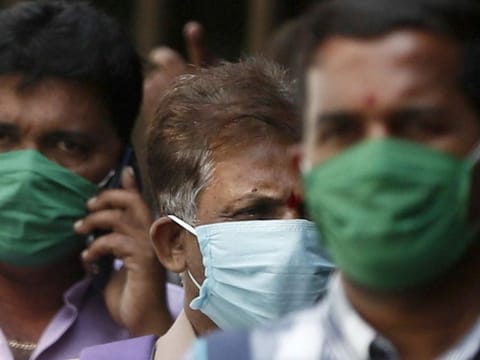 Men wearing protective masks walk inside the premises of a hospital where a special ward has been set up for the coronavirus disease in Mumbai on March 17, 2020.