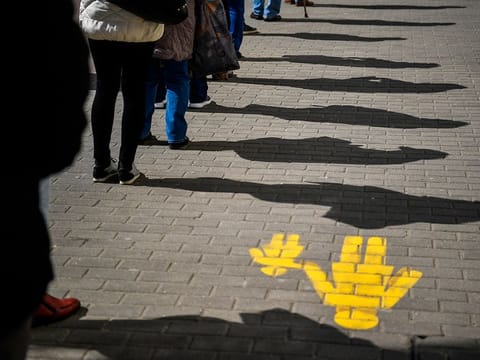 Social distancing: People keep their distance as they queue up in front of a post office 