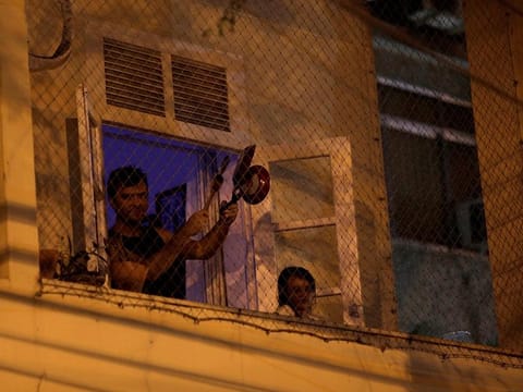 A man bangs a pot at the window of his house as he protests against Brazilian President Jair Bolsonaro during the coronavirus disease (COVID-19) outbreak in Rio de Janeiro, Brazil, March 18, 2020. 