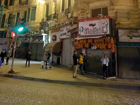 People walk in front of closed shops, after Egyptian Prime Minister Mostafa Madbouly ordered all restaurants, cafes, cafeterias, night clubs, shopping malls and shops to shut their doors from 7pm due to the coronavirus disease (COVID-19) outbreak in Cairo.