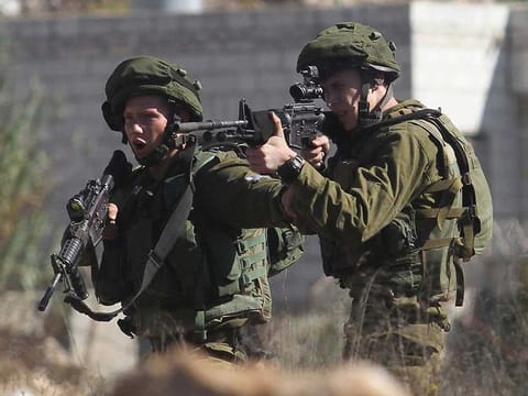 Israeli soldiers fire at Palestinian protesters in Gaza.