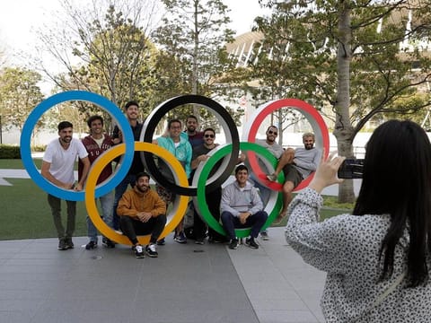 A group of students from Uruguay pose for a souvenir picture on the Olympic Rings outside the Olympic Stadium in Tokyo in March. The Games have been subsequently postponed by an year due to the coronavirus pandemic.