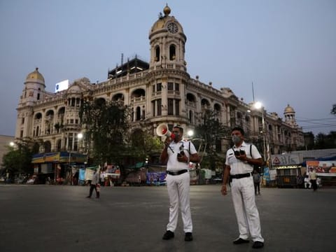 A police officer uses a megaphone advising people to vacate the roads after the lockdown by West Bengal state government to limit the spreading of coronavirus disease (COVID-19), in Kolkata on March 23, 2020.