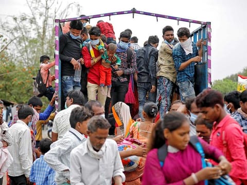 Migrant workers and their families board a truck to return to their villages. India has chosen an odd combination of strategies in its fight against the coronavirus — a harsh lockdown on economic activity and a meagre fiscal response to the loss of jobs and incomes.
