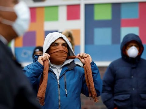 People wait in line to be tested for coronavirus disease (COVID-19) while wearing protective gear, outside Elmhurst Hospital Center in the Queens borough of New York City on March 25, 2020.