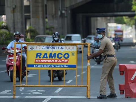 A policeman sets a barrier at a roadblock. India on Friday extended its nationwide lockdown for two more weeks.