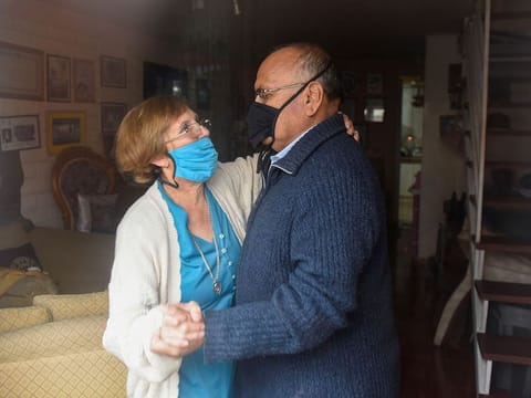 The parents of Gonzalo Acuna, who are practicing isolation to prevent themselves from catching the coronavirus disease (COVID-19), dance inside his house while he plays his accordion outside to lift their spirits in Concepcion, Chile, March 26, 2020.