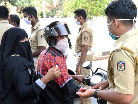 Police question commuters who defied a 21-day nationwide lockdown, in Kochi on Friday.