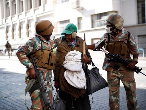 Soldiers of the South African National Defence Force (SANDF) escorts a homeless woman to a gathering point in the Johannesburg CBD (File) 