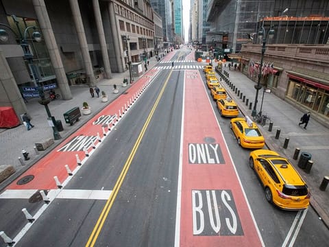 Yellow cabs line an empty 42nd St. waiting for fares outside Grand Central Terminal, in New York.
