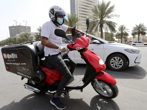 A delivery man rides his motorbike to deliver food orders for customers, as restaurants are closed, following the outbreak of coronavirus, in Riyadh, Saudi Arabia, March 17, 2020. REUTERS/Ahmed Yosri