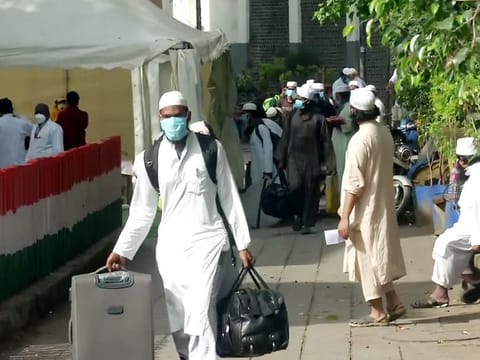People from Markaz building wear a protective mask as they walk to board a bus that will be taken to the hospital amid concerns about the spread of coronavirus disease at Nizamuddin Area in New Delhi on Tuesday. 