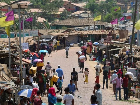 Rohingya refugees, without wearing any mask or any other safety gear as a preventive measure against coronavirus, gather along a market area in Kutupalong refugee camp in Ukhia  