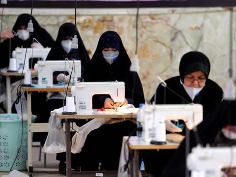 Iranian women, members of paramilitary organisation Basij, make face masks and other protective items at a mosque in the capital Tehran.
