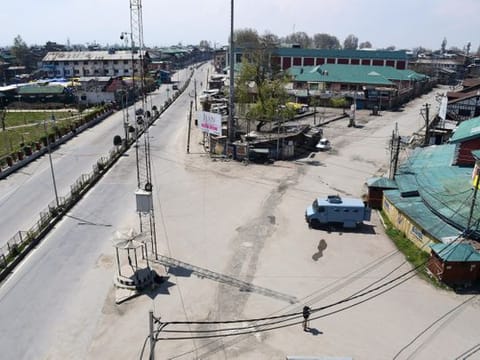 Policeman stand guard on a deserted street during the lockdown as a preventive measure against the COVID-19 coronavirus, in Srinagar, Kashmir
