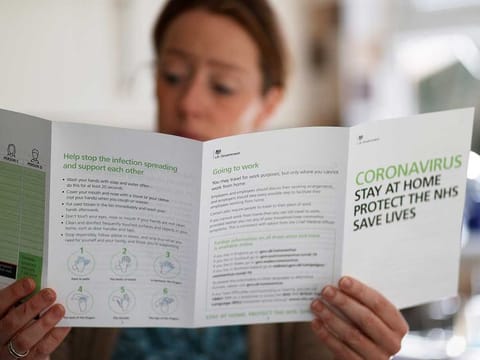 A woman reads a leaflet from the UK government after it arrived at her house in Manchester as the spread of the coronavirus disease (COVID-19) continues, Manchester, Britain, April 7, 2020. 