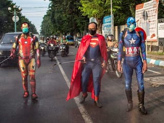 COVID-19: Police officers in superhero costumes disinfect motorists in Indonesia
