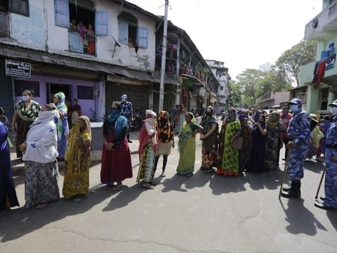 Indian women stand in a queue to receive face masks, gloves and hand sanitizers distributed by the Rapid Action Force during lockdown to control the spread of the new coronavirus in Ahmedabad on April 11.