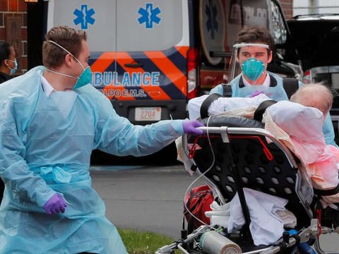 Cataldo Ambulance medics bring a patient who has tested positive for the coronavirus disease (COVID-19) to the ambulance at an assisted living facility in Chelsea, Massachusetts, US, on April 10, 2020.