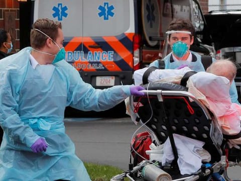 Cataldo Ambulance medics bring a patient who has tested positive for the coronavirus disease (COVID-19) to the ambulance at an assisted living facility in Chelsea, Massachusetts, US, on April 10, 2020.