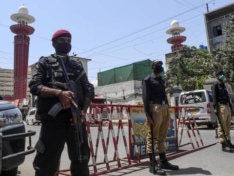 Security personnel wearing facemasks stand guard outside a closed mosque during a government-imposed nationwide lockdown as a preventive measure against the COVID-19 coronavirus, in Karachi.