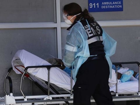 A medical worker attends to a patient at a special coronavirus intake area at Maimonides Medical Centre in the Borough Park neighborhood of the Brooklyn borough of New York City on April 11, 2020. 