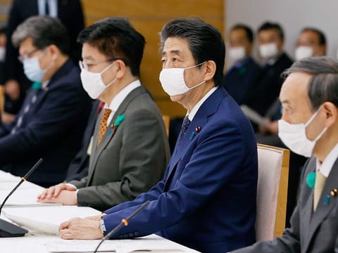 Japanese Prime Minister Shinzo Abe (centre) wearing a face mask, speaks, during the country's coronavirus task force meeting at his official residence in Tokyo Thursday, April 16, 2020. 