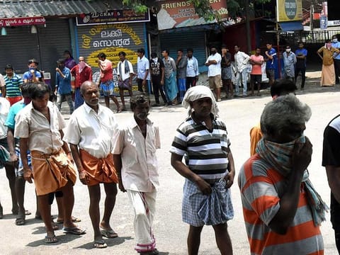 People stand in a queue as they wait for their turn to get the food packet which is being distributed by volunteers during the lockdown in Kochi on Tuesday. 