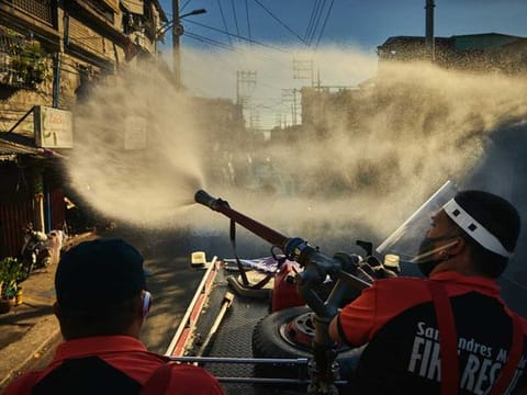Firefighters spray disinfectant along a road in Manila, Philippines, Monday, April 6, 2020, in an effort to keep the coronavirus from spreading. Philippines President Rodrigo Duterte's lockdown of Luzon, the Philippines' largest island and home to Manila, is moving into its second month, plunging the people of San Roque, a suburb of Quezon City, even deeper into poverty as the virus continues to rage.