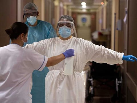 A healthcare worker is disinfected after attending to COVID-19 coronavirus patients at the CEMTRO private clinic in Madrid on April 17, 2020. Spain's death toll increased to nearly 19,500, government figures showed. The country reported 585 new fatalities in the past 24 hours, but said it had revised its counting mechanism, making the figures difficult to compare with previous tolls. 