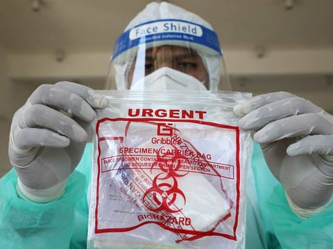 A member of medical staff holds a swab tested during a drive-thru for the coronavirus disease (COVID-19) testing, at a makeshift centre in Shah Alam, Malaysia April 20, 2020.