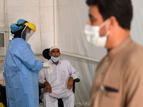 A health worker takes samples from an expatriate worker to check for the novel coronavirus at a testing centre in the Al Quaz area of Dubai.  
