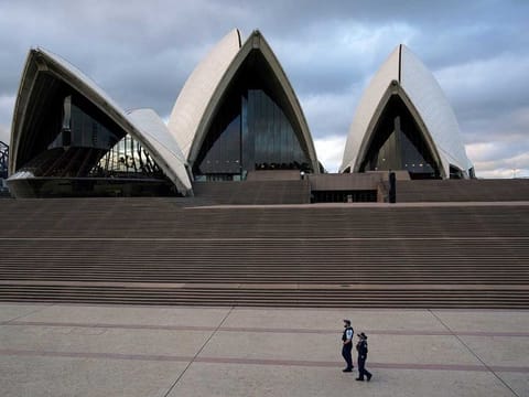 Police officers patrol near the Sydney Opera House following the implementation of stricter social-distancing and self-isolation rules to limit the spread of the coronavirus disease (COVID-19) in Sydney, Australia, April 6, 2020. 
