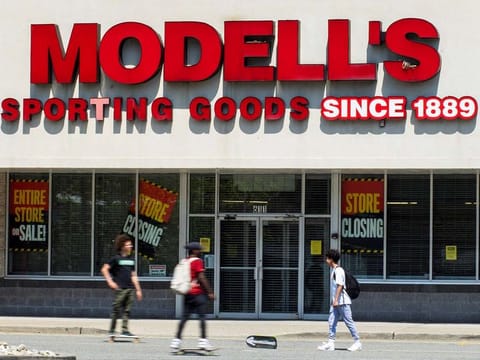 People walk near the Modell's store with 'closing' placards displayed in the windows due to the outbreak of the coronavirus disease (COVID-19) in Newport, New Jersey, U.S. April 25, 2020. 